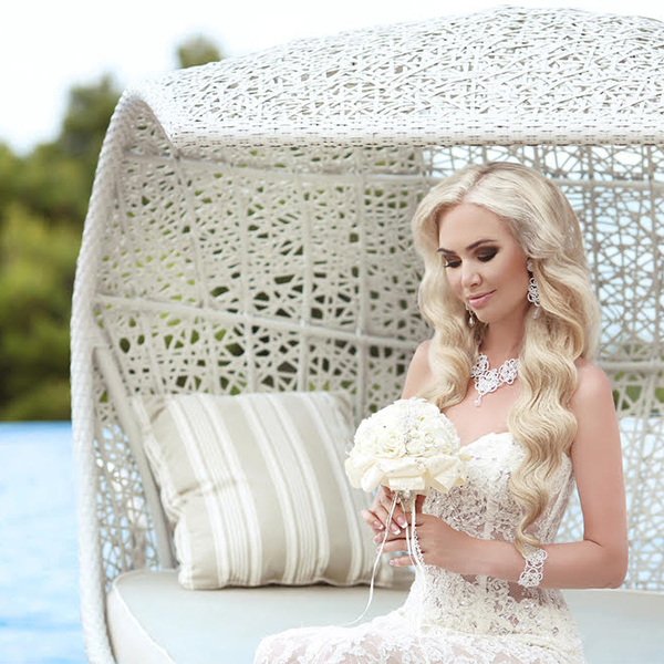 A bride on her wedding day with luminous, trendy blonde hair styled in soft waves